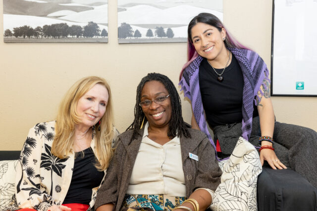 Three women posing together for a photograph.